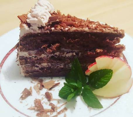 Homemade apple cake with powdered sugar on a wooden table