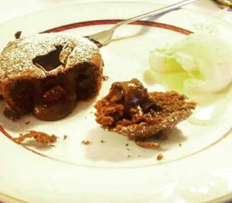 Traditionelles Südtiroler Bauernhaus mit Blumen und Holzbalkon im Sonnenschein