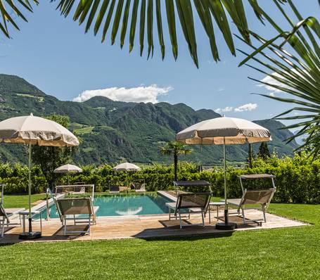Außenansicht des Garni Hotel Sonngart in Andrian mit Garten und Freibad an einem sonnigen Tag Außenansicht des Garni Hotel Sonngart in Andrian mit Garten und Freibad an einem sonnigen Tag