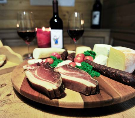 Traditionelle Südtiroler Speckbrett-Jause mit Brot, Schinken und Käse auf Holzbrett